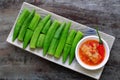 Rectangle plate boiled okra with fermented tofu on wooden background