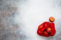 Top view of red apples in the red string shopping bag on the concrete background.