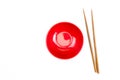 Top view of red bowl with wooden chopsticks on a white background. Isolated background Royalty Free Stock Photo