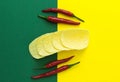 Top view, red chili peppers and chips on a yellow-green background Royalty Free Stock Photo