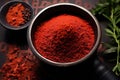a top view of a red chili powder in a black mortar with a pestle