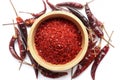 Top view of Red chilli pepper seedless flakes in wooden bowl and dried red chili pepper on white background. Royalty Free Stock Photo