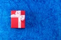 Top view of a red colored gift box with white ribbon and blue surface. Couple gift concept Royalty Free Stock Photo