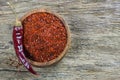Top view red dried crushed hot chili peppers and chili flakes or powder in bowl on wooden rustic background Royalty Free Stock Photo