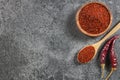 Top view red dried crushed hot chili peppers and chili flakes or powder in wooden spoon and bowl Royalty Free Stock Photo