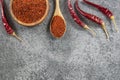 Top view red dried crushed hot chili peppers and chili flakes or powder in wooden spoon and bowl Royalty Free Stock Photo