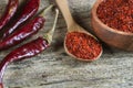 Top view red dried crushed hot chili peppers and chili flakes or powder in wooden spoon and bowl on wooden rustic background Royalty Free Stock Photo