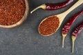 Top view red dried crushed hot chili peppers and chili flakes or powder in wooden spoon and bowl Royalty Free Stock Photo