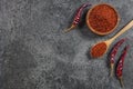 Top view red dried crushed hot chili peppers and chili flakes or powder in wooden spoon and bowl Royalty Free Stock Photo