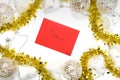 Top view on a red envelope with text `To Santa` surrounded with festive white and golden Christmas decorations