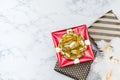 Top view of red glossy present box with golden bow and ribbon la Royalty Free Stock Photo