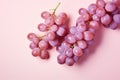 Top view of red grapes on pastel pink background