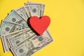 Top view of red heart on american dollars,yellow background.Red heart on a pile of banknotes using as love to money.Cash Royalty Free Stock Photo