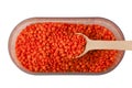 Top view of red lentils in a container with wooden spoon isolated on white background Royalty Free Stock Photo