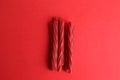 Top view of the red licorice sticks on a red background Royalty Free Stock Photo