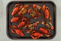 Top view of red lobsters in tray on wooden table.