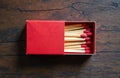 Top view of red matchbox and matchsticks on wooden table. Red matches lie in container. Ignition sticks for making fire. Matchbox Royalty Free Stock Photo