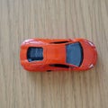 Top view of a red Mattel Hot Wheels toy car on a wooden surface