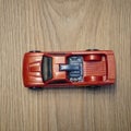 Top view of a red Mattel Hot Wheels toy car on a wooden surface
