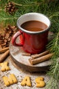 Top view of red mug with chocolate, on wooden table with Christmas decoration, cinnamon, branches and pine cones, Royalty Free Stock Photo