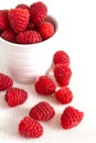 Top view of red raspberries in a white bowl on white wooden board Royalty Free Stock Photo