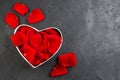 Top view red rose petals inside heart shaped box for valentines day on dark background Royalty Free Stock Photo