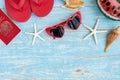 Top view of red slippers summer hat sunglasses and passport on blue wooden background,Flat lay of summer and travel equipment with