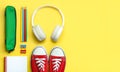 Top view of red sneakers, pencil case, headphones and school supplies with space for text. Back to school concept