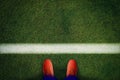 Top view of red soccer boots on the green field