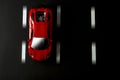 Top view of a red sports car on an asphalt background with road lanes Royalty Free Stock Photo