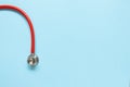 Top view of red stetoscope on blue background. Medicine concept. Royalty Free Stock Photo