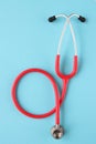 Top view of red stetoscope on blue background. Medicine concept. Royalty Free Stock Photo
