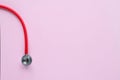 Top view of red stetoscope on pink background. Medicine concept. Royalty Free Stock Photo