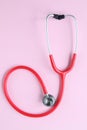 Top view of red stetoscope on pink background. Medicine concept. Royalty Free Stock Photo