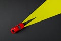 Top view of red toy car and yellow headlights on dark gray background Royalty Free Stock Photo