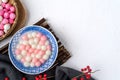 Top view of red and white tangyuan in blue bowl on white background for Winter solstice