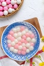 Top view of red and white tangyuan in blue bowl on white background for Winter solstice