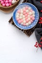 Top view of red and white tangyuan in blue bowl on white background for Winter solstice