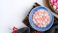 Top view of red and white tangyuan in blue bowl on white background for Winter solstice