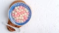 Top view of red and white tangyuan in blue bowl on white background for Winter solstice