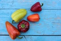 Red, yellow and orange bell peppers on light blue wooden background. Fresh summer or autumn vegetables harvest Royalty Free Stock Photo