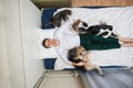 Man dogs and cat lying on bed with blue sheet Royalty Free Stock Photo