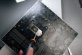 Top view of repairman using screwdriver to carefully remove old thermal paste from CPU socket of motherboard, preparing Royalty Free Stock Photo