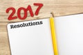 Top view of 2017 resolutions red number with blank open notebook