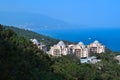 top view of resort town with white buildings on shore of Black Sea bay among mountains, blue water, summer, green forest Royalty Free Stock Photo