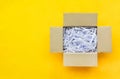 Top view of reuse shredded paper documents in brown paper cardboard isolated on yellow background with copy space, flat lay Royalty Free Stock Photo