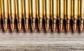 Top view of rifle full metal jacket bullets in a row on wooden background with copy space Royalty Free Stock Photo