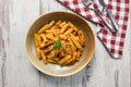 Top view of rigatoni pasta with arrabiata sauce on a white wooden table