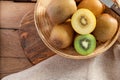 Top view ripe golden kiwi fruit and green kiwi fruit in wood basket on wooden table background. Healthy fruits concept