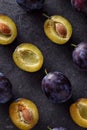Top view on ripe plums, whole and slices on dark background Royalty Free Stock Photo